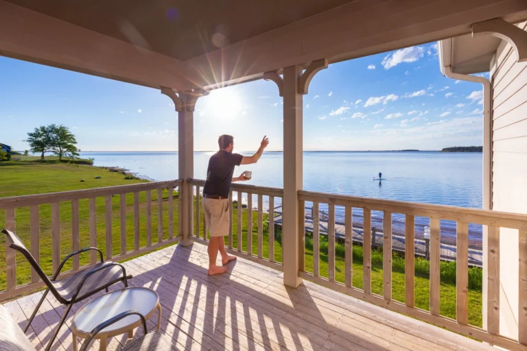 Guest enjoying oceanfront views from the balcony at Northport Pier Inn in Western Prince Edward Island.