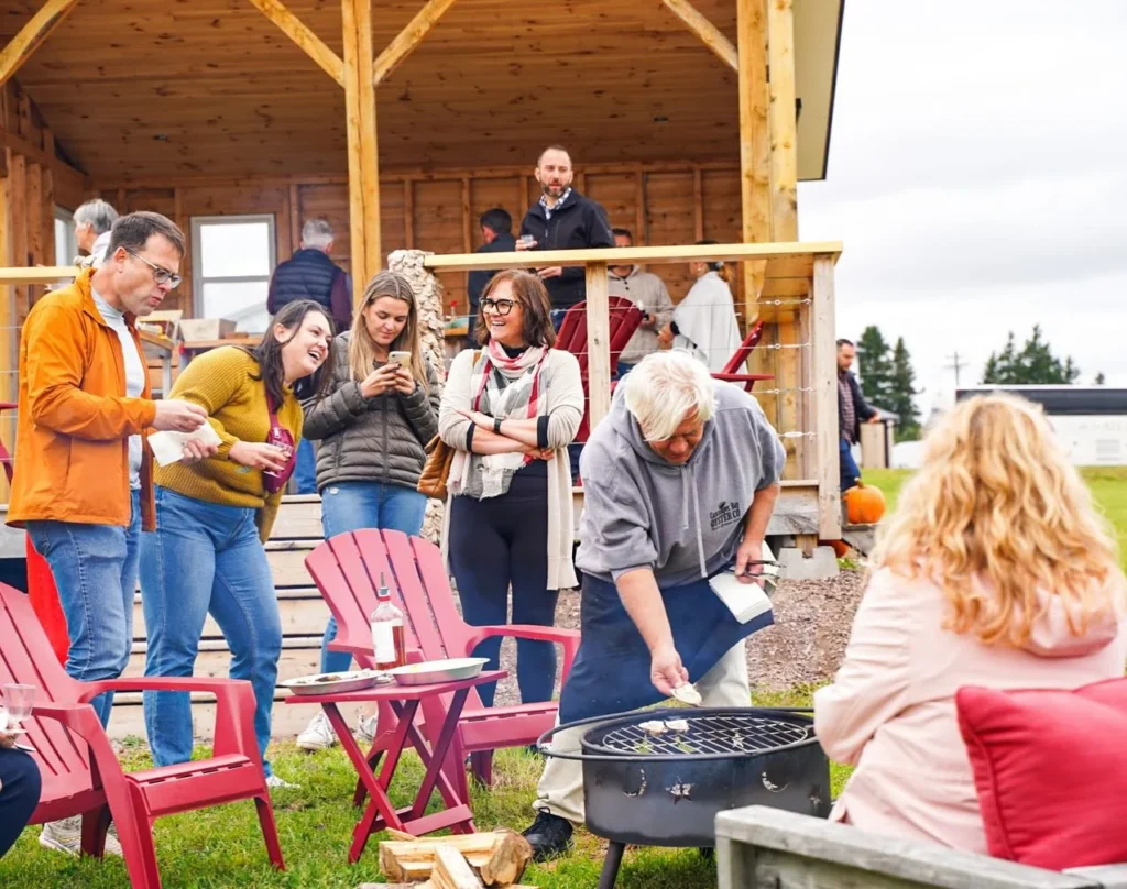 Visitors gather around a fire pit enjoying fresh oysters and local hospitality at Cascumpec Bay Oyster Co. in Western Prince Edward Island.