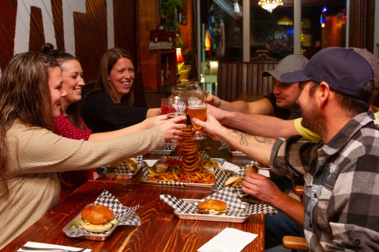 Friends enjoying burgers and craft beer together at Backwoods Burger – Craft Beer Cookhouse in Western Prince Edward Island.