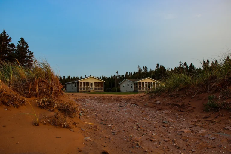 Oceanfront cottages surrounded by red sand dunes at Doucette's By The Beach Oceanfront Cottages in Western Prince Edward Island.