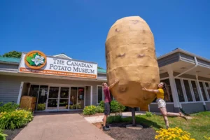 Visitors posing beside the Giant Potato outside the Canadian Potato Museum in O'Leary, Prince Edward Island.