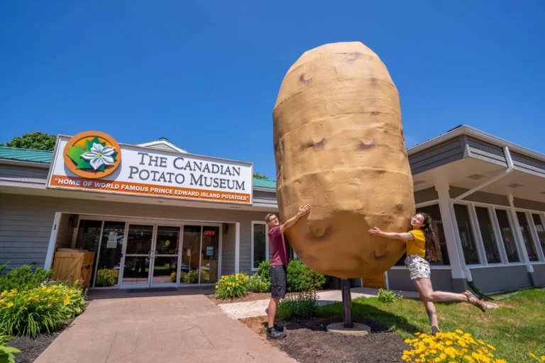 Visitors posing beside the Giant Potato outside the Canadian Potato Museum in O'Leary, Prince Edward Island.