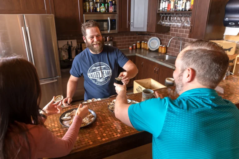 Guests enjoying freshly shucked oysters during a tasting experience at Valley Pearl Oysters in Western Prince Edward Island.